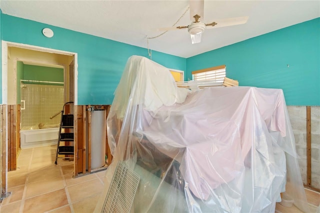 bedroom featuring ceiling fan, light tile patterned floors, and ensuite bath