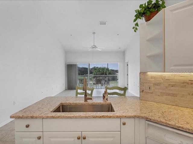 kitchen with kitchen peninsula, ceiling fan, and white cabinets