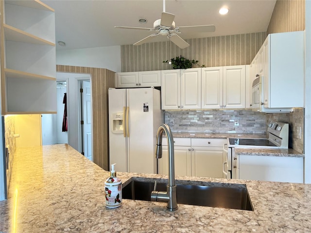 kitchen with white appliances, sink, decorative backsplash, ceiling fan, and white cabinetry