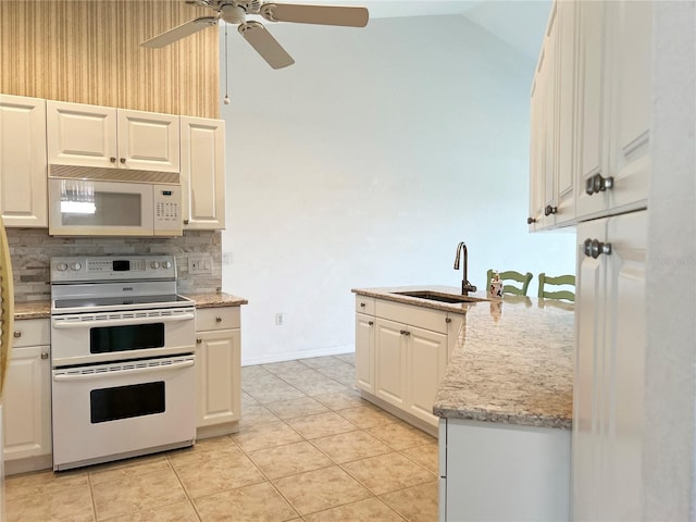 kitchen featuring backsplash, white appliances, vaulted ceiling, sink, and light tile patterned floors