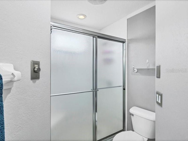 bathroom with walk in shower and toilet