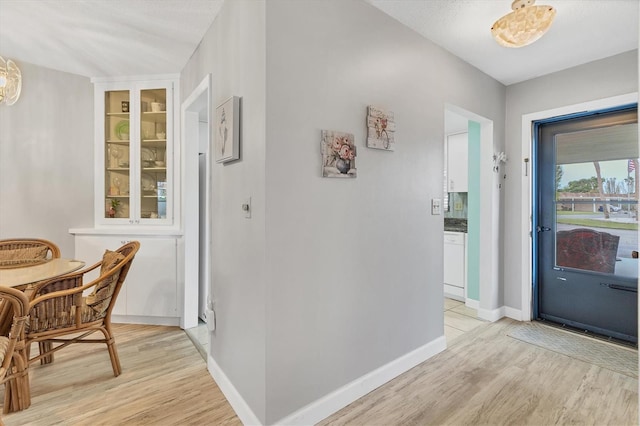 foyer entrance with light wood-type flooring and baseboards