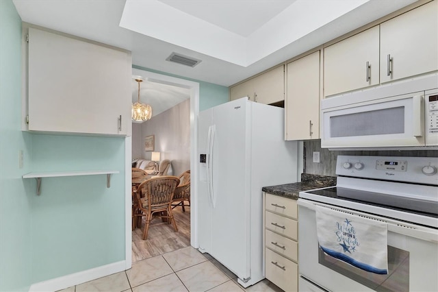 kitchen featuring white appliances, a chandelier, and dark countertops