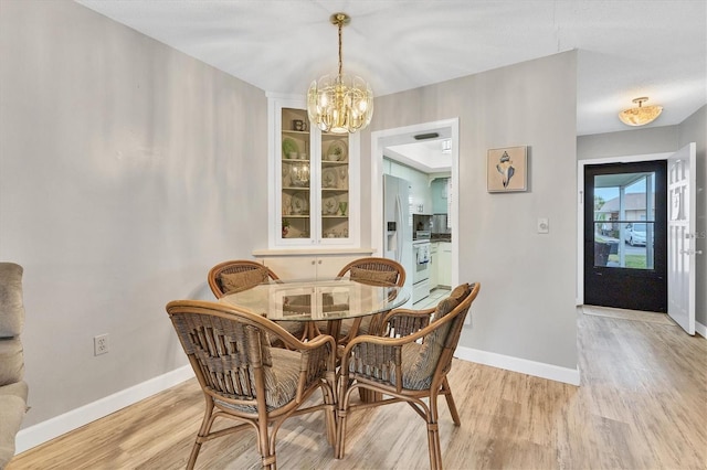 dining area with a chandelier and light hardwood / wood-style flooring