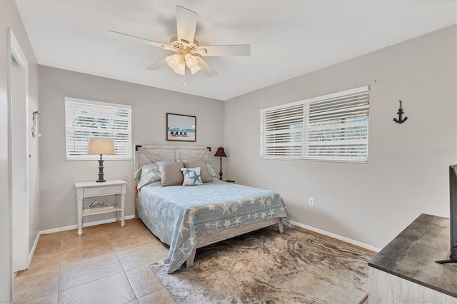 bedroom featuring baseboards, ceiling fan, and light tile patterned floors