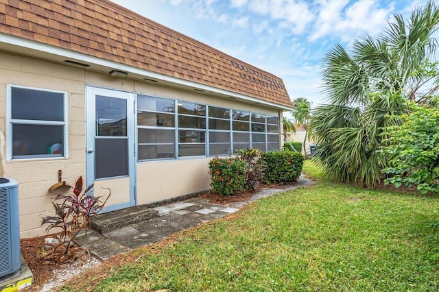 view of home's exterior featuring central AC unit and a yard