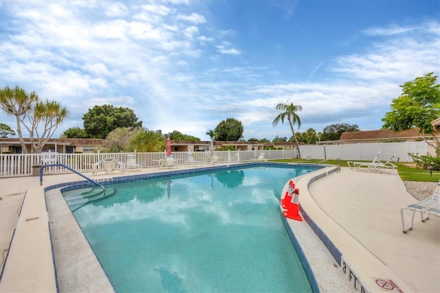 community pool featuring fence and a patio area