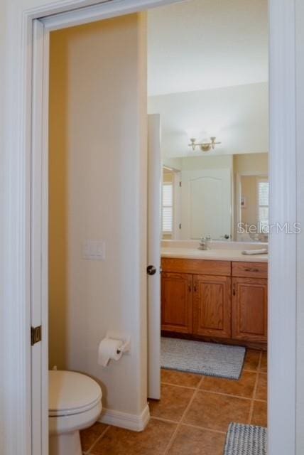 bathroom with tile patterned flooring, vanity, and toilet