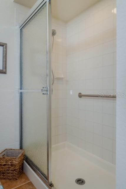 bathroom with tile patterned flooring and an enclosed shower