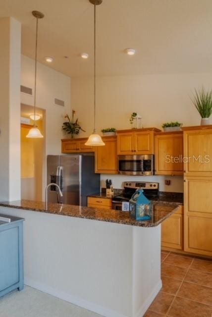 kitchen with kitchen peninsula, dark stone countertops, hanging light fixtures, and appliances with stainless steel finishes