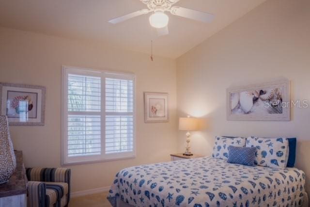 bedroom featuring ceiling fan, carpet floors, and vaulted ceiling