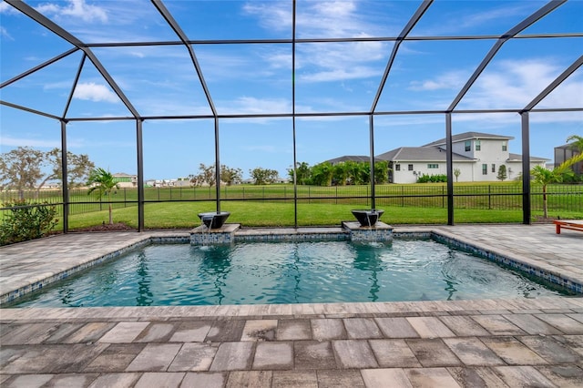 view of pool with pool water feature, glass enclosure, a patio, and a yard