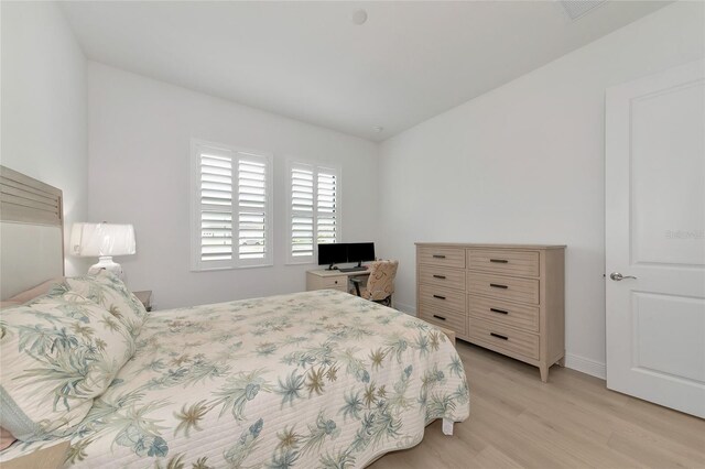 bedroom featuring lofted ceiling and light hardwood / wood-style flooring