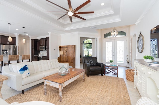 living room featuring ceiling fan, a tray ceiling, french doors, and ornamental molding