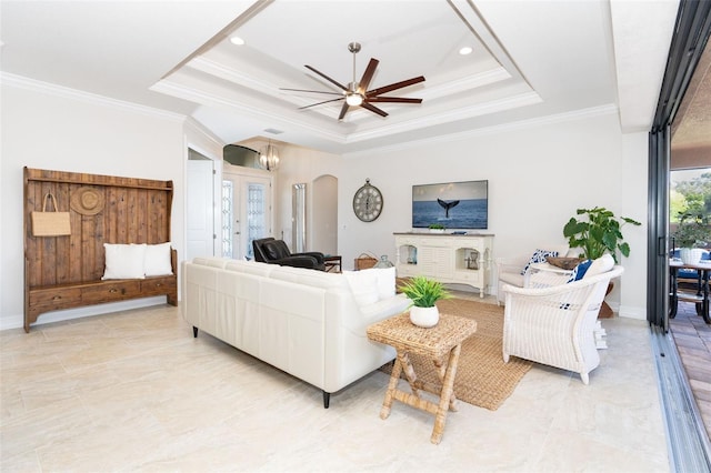 living room with ceiling fan, ornamental molding, and a raised ceiling