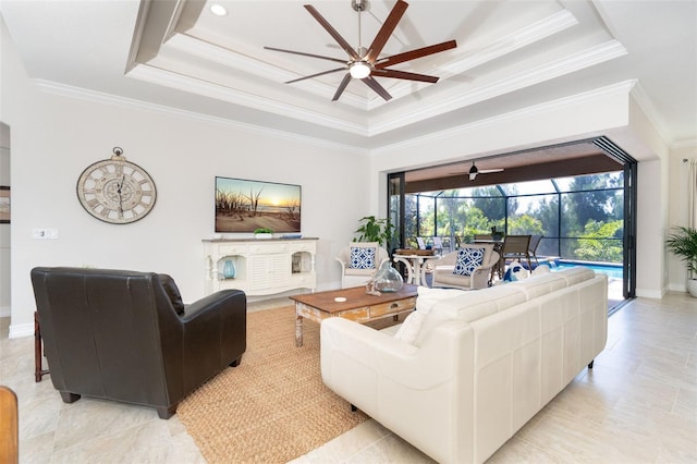 living room featuring a tray ceiling, ceiling fan, and crown molding