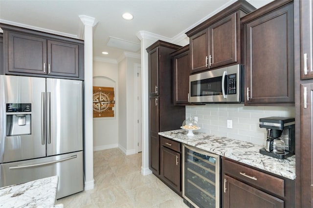 kitchen featuring stainless steel appliances, beverage cooler, backsplash, and light stone counters