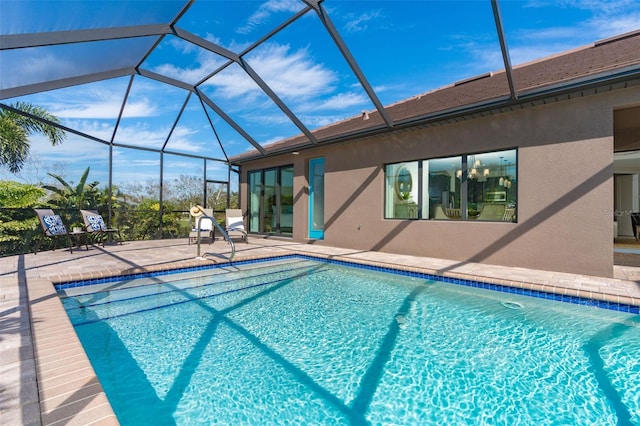 view of pool with a patio and glass enclosure