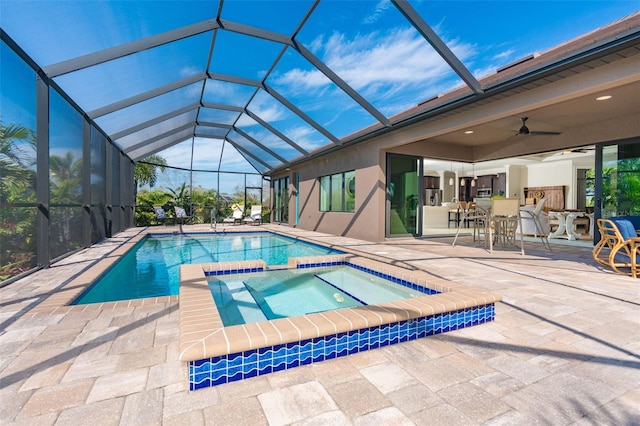 view of swimming pool with glass enclosure, a patio, ceiling fan, and an in ground hot tub