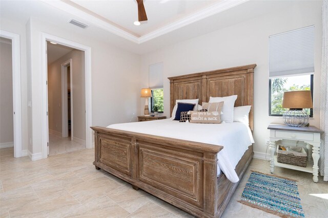 bedroom featuring a tray ceiling, ceiling fan, and crown molding