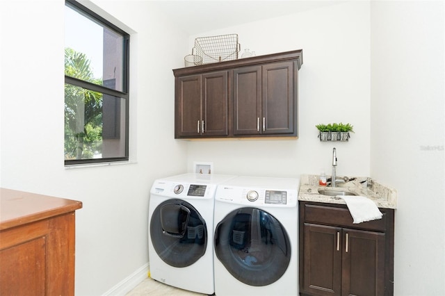 washroom with cabinets, sink, and washing machine and clothes dryer