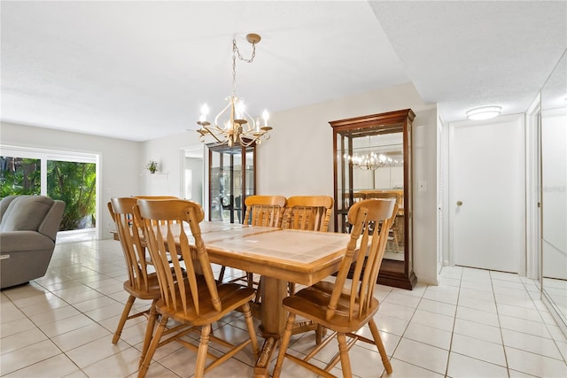 dining space featuring light tile patterned floors, a textured ceiling, and a chandelier