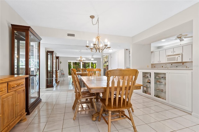 dining room featuring light tile patterned flooring and ceiling fan with notable chandelier