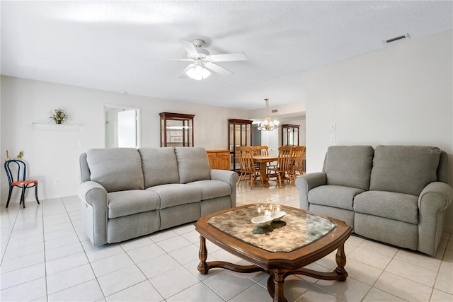 tiled living room with ceiling fan with notable chandelier and a textured ceiling