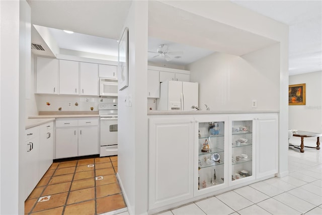 kitchen with white cabinetry, tasteful backsplash, light tile patterned floors, ceiling fan, and white appliances