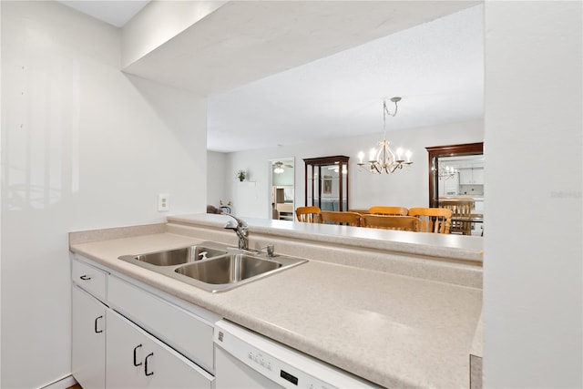 kitchen featuring hanging light fixtures, dishwasher, sink, and white cabinets