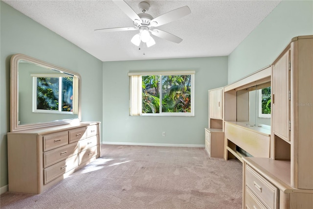 unfurnished bedroom featuring light carpet, a textured ceiling, and ceiling fan