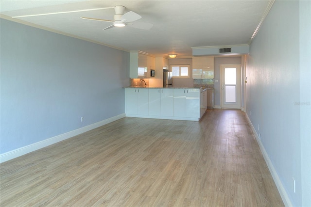 kitchen with freestanding refrigerator, crown molding, ceiling fan, light wood-style floors, and white cabinets