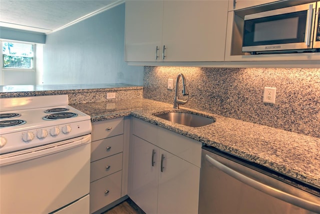 kitchen with backsplash, ornamental molding, stainless steel appliances, sink, and stone countertops