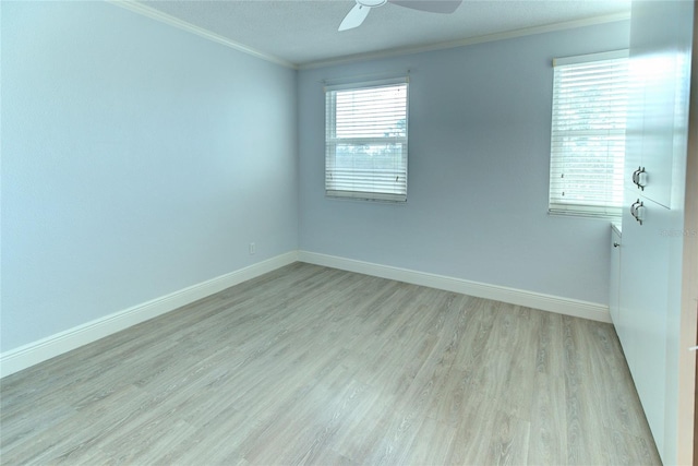 spare room with ornamental molding, baseboards, wood finished floors, and a ceiling fan