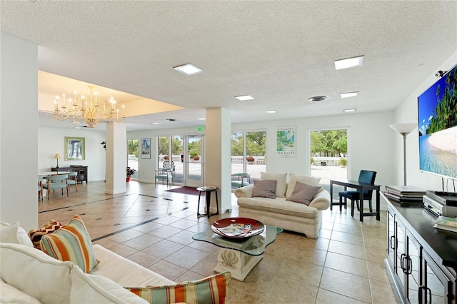 living room featuring a chandelier, light tile patterned flooring, healthy amount of natural light, and a textured ceiling