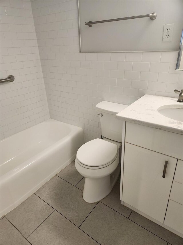 full bathroom featuring vanity, bathing tub / shower combination, tile patterned floors, toilet, and tile walls