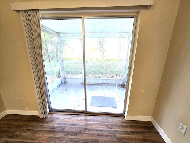 doorway to outside with dark hardwood / wood-style flooring and a healthy amount of sunlight