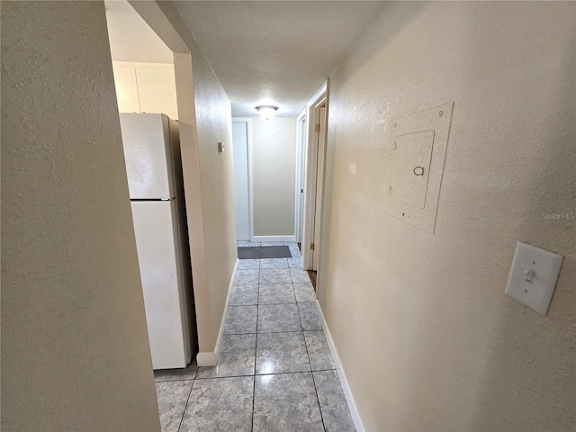 hallway with electric panel, light tile patterned flooring, and a textured ceiling