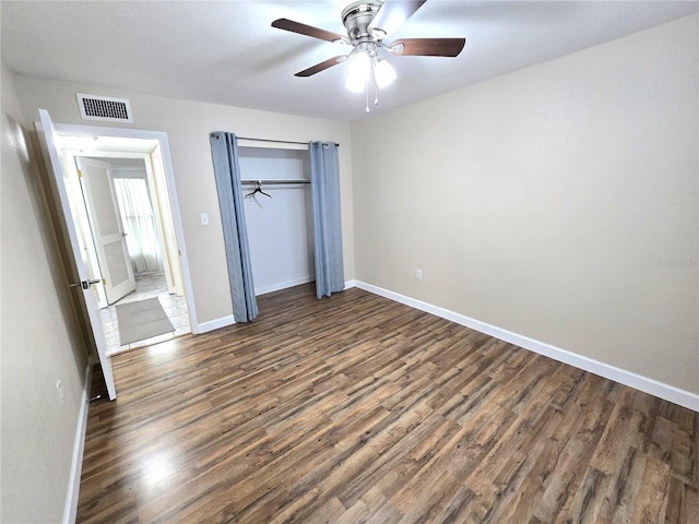 unfurnished bedroom featuring ceiling fan and dark hardwood / wood-style floors