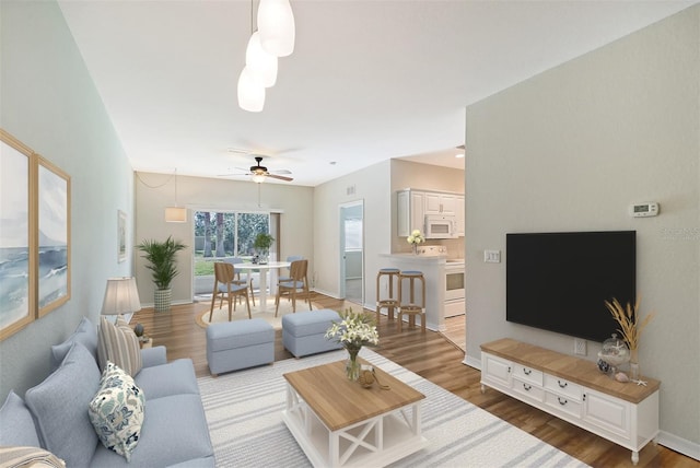 living room featuring ceiling fan and wood-type flooring