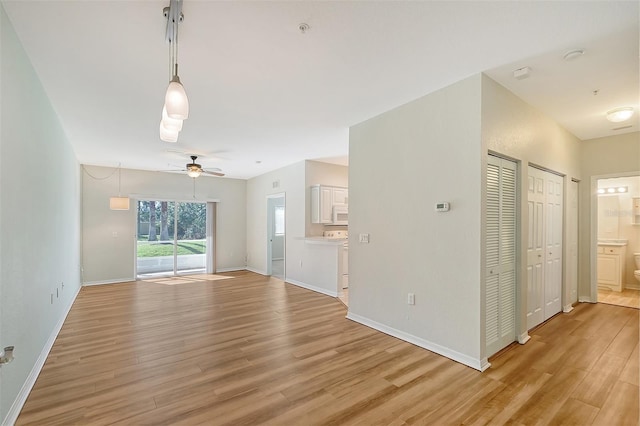 unfurnished living room with ceiling fan and light hardwood / wood-style floors