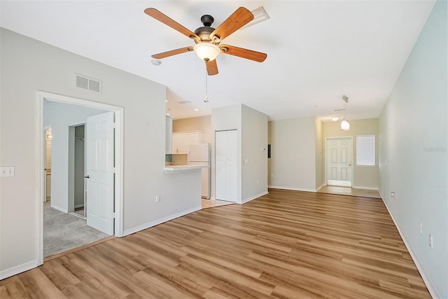 unfurnished living room with ceiling fan and light hardwood / wood-style flooring