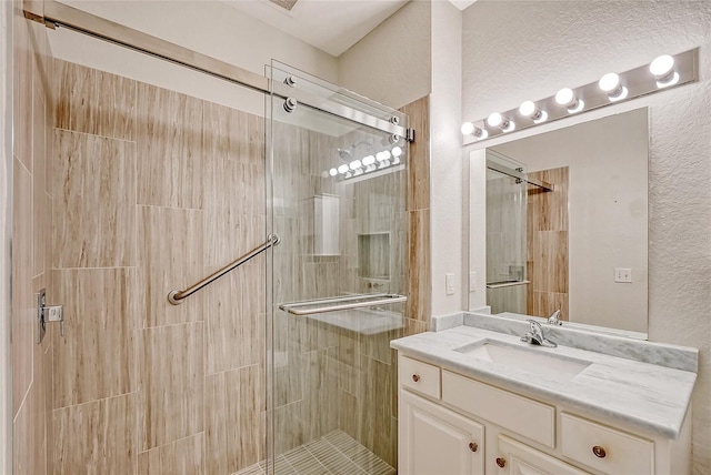 bathroom with walk in shower and vanity