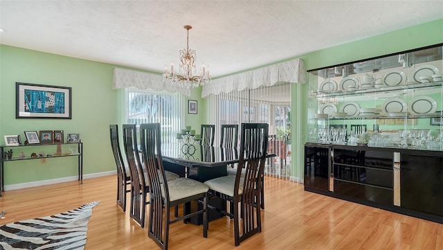 dining space with an inviting chandelier and light wood-type flooring