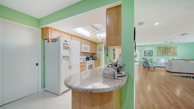 kitchen featuring light brown cabinets, light stone countertops, light hardwood / wood-style floors, white appliances, and ceiling fan