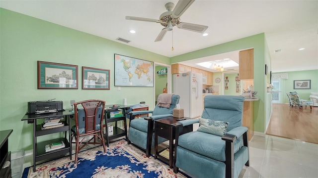 living area with light tile patterned floors and ceiling fan