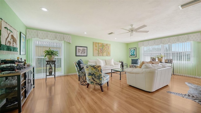 living room with light hardwood / wood-style floors and ceiling fan