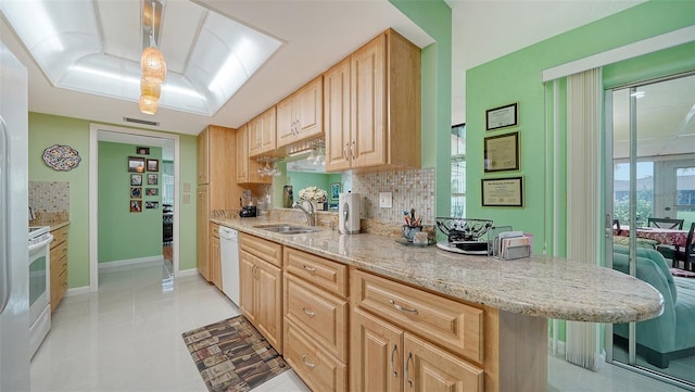 kitchen featuring sink, tasteful backsplash, light brown cabinets, light stone countertops, and white appliances