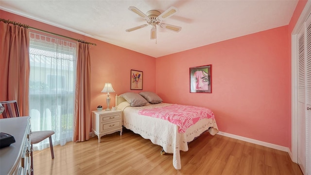 bedroom with light hardwood / wood-style flooring, ceiling fan, and a closet