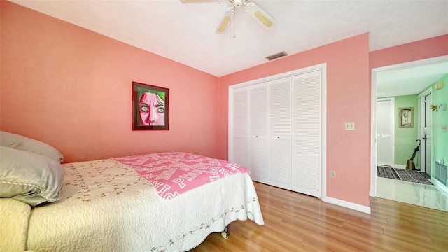 bedroom with a closet, hardwood / wood-style floors, and ceiling fan